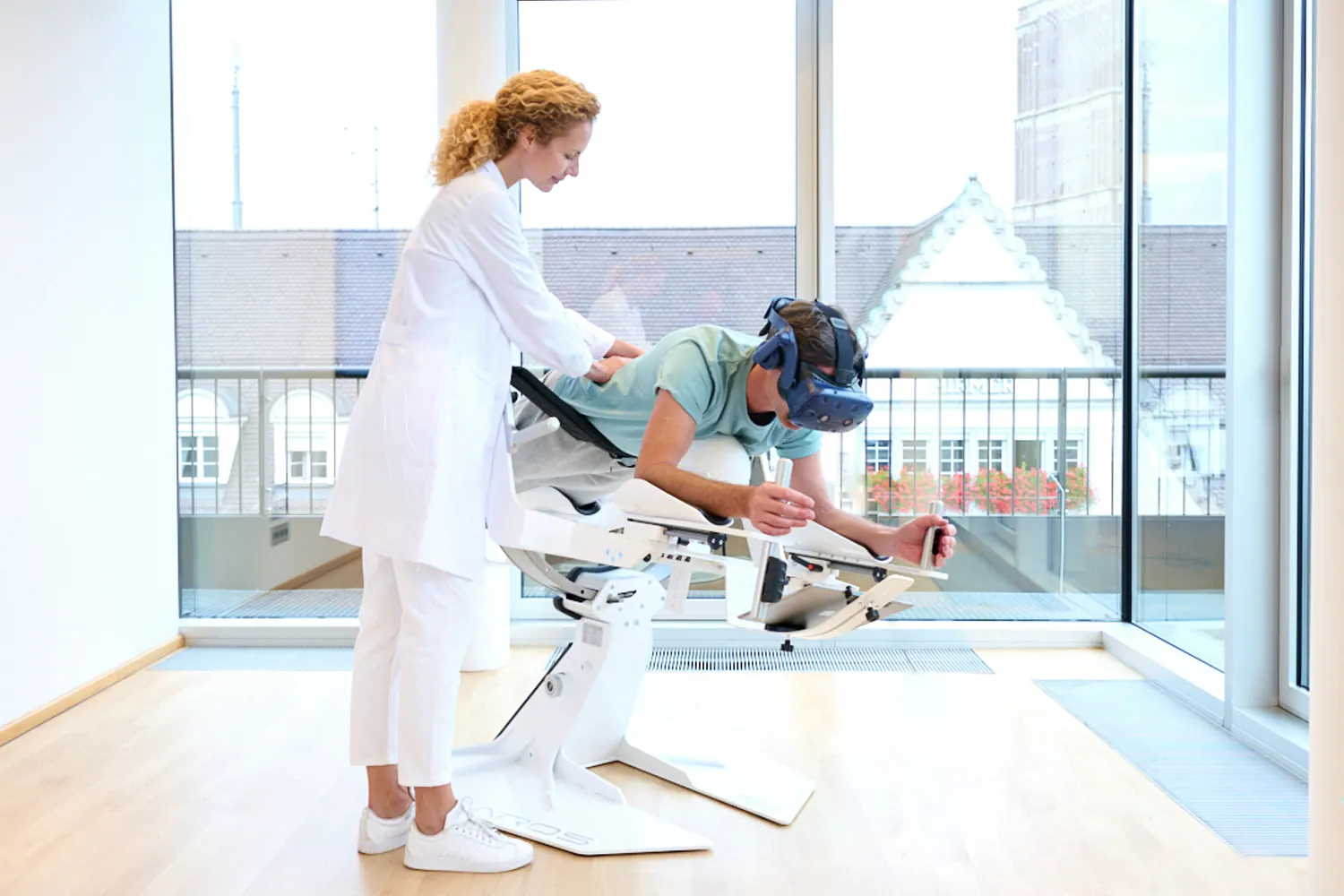 Therapeutin begleitet einen Patienten mit VR-Brille beim Rumpftraining auf dem ICAROS Health