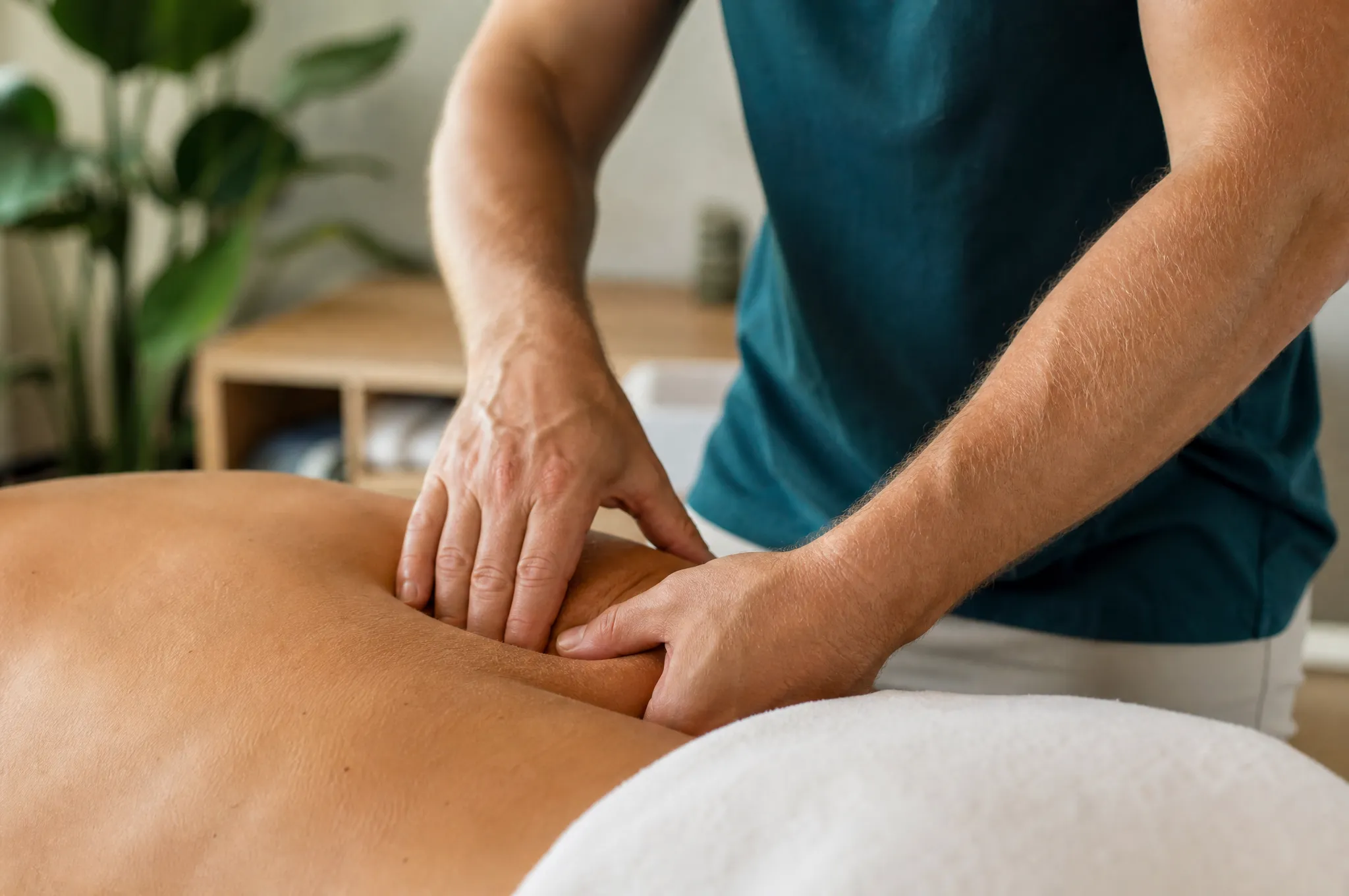 Physiotherapeutin behandelt den unteren Rücken einer Patientin mit manueller Technik