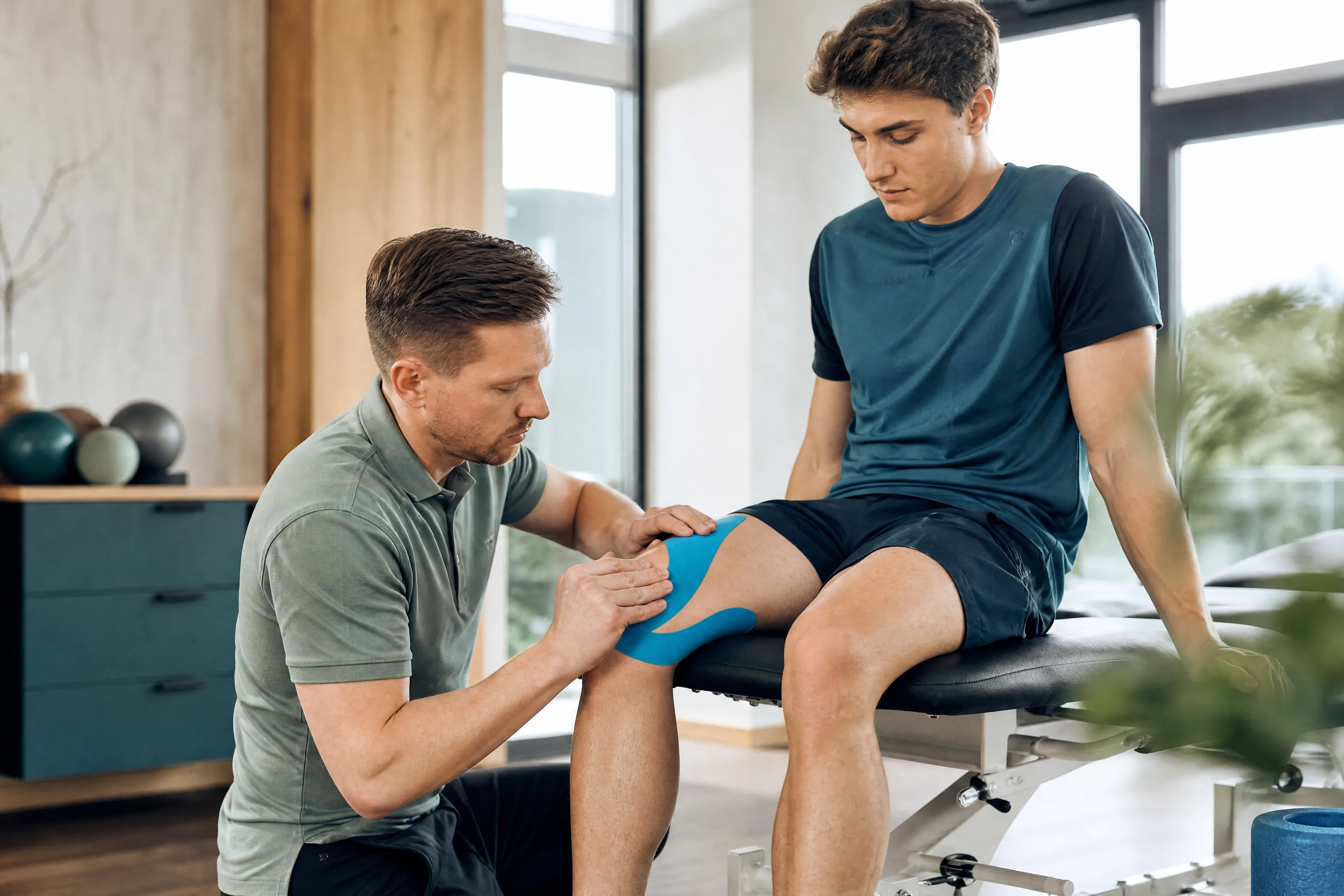 Therapeut betreut einen Sportler beim Aufbautraining
